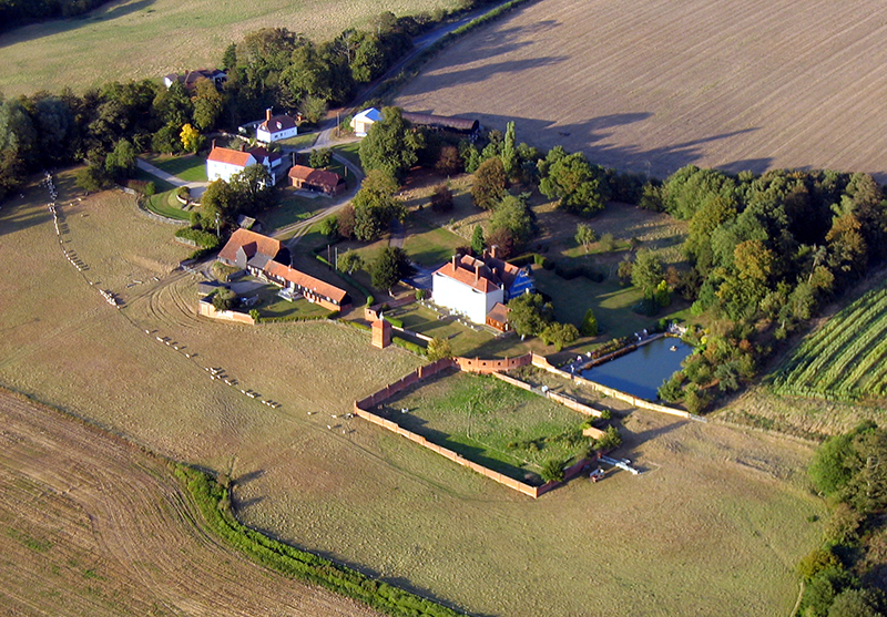 There are many fine country houses in Essex, creating ideal retreats for the financially successful from the City of London. This house was clearly a Manor house in times past, with farm buildings and cottages for those in its employ, a walled garden and a fishing lake. Aerial views such as this are often experienced on our hot air ballon flights over the Essex countryside